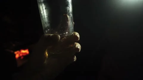 Close-up of a split sausage inside a glass with drink and ice grabbing it with Stock Footage 170020024