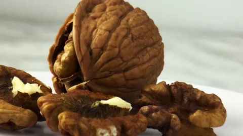 Close-up. A split walnut rotates around its axis on a light background Stock Footage 234998598