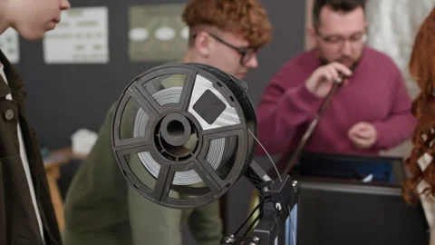 Close up of Spool of Gray Filament Being Fed Into 3D Printer During School Class Stockbeeldmateriaal 335691196