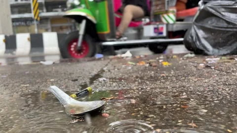 Close up spoon and battery on sidewalk on a rainy day. Vehicles on road slow mo Video stock 197101386