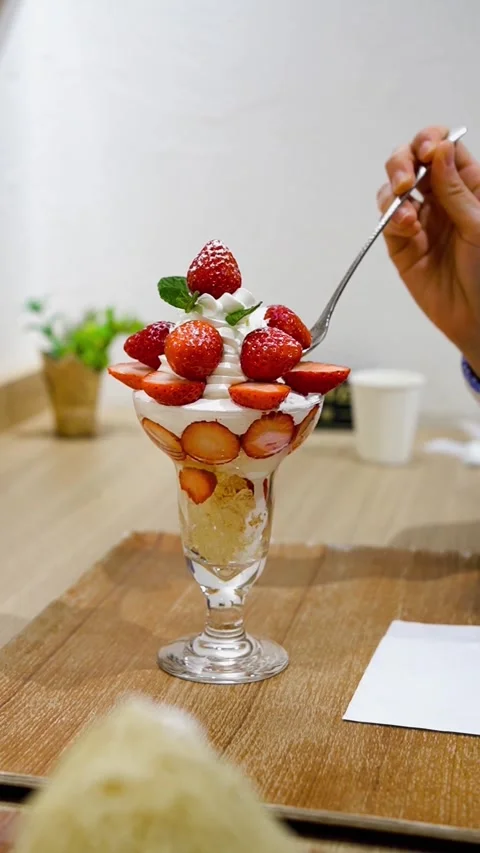 Close-up of a Spoon Picking Up a Fresh Strawberry from a Parfait Stock Footage 333740774