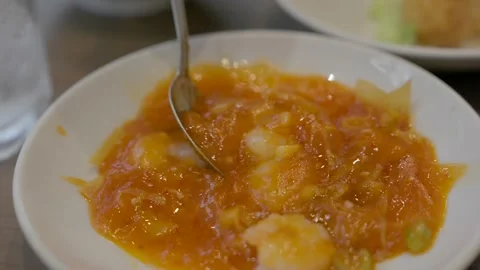 Close up spoon picks up shrimp in tomato sauce Chinese dish Stock Footage 228998810