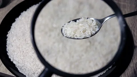 A close-up of a spoon with rice on it through a magnifying glass and a large Stock Footage 149845033