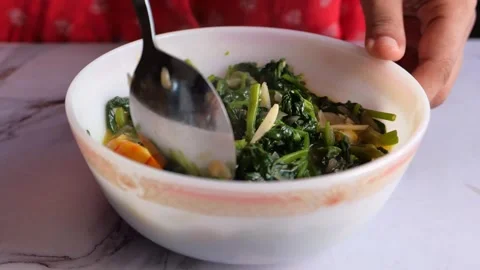 Close up of a spoon scooping cooked greens and shrimp from a bowl, healthy .. Stock Footage 333158619