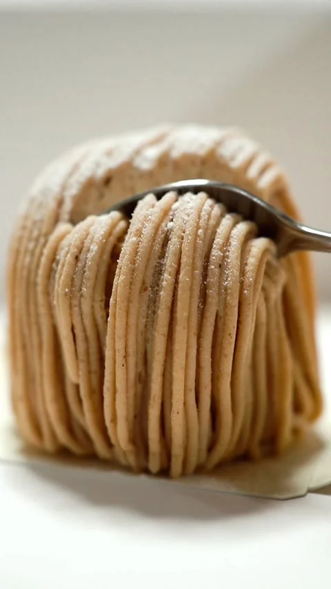 Close-up of a spoon scooping creamy chestnut puree from a Mont Blanc cake Stock Footage 335784271
