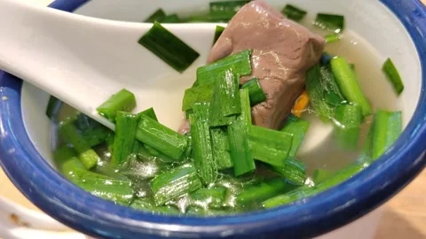 Close-Up of Spoon Scooping Duck Blood Soup with Chives Stock-Footage 334224980