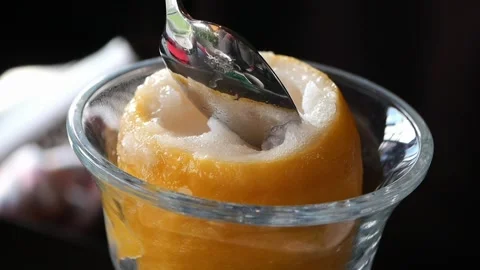 Close-up of Spoon Scooping Refreshing Lemon Sorbet from Fruit Stock Footage 334908797