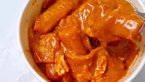 Close up of spoon scooping spicy rose tteokbokki korean rice cake Video stock 336313508
