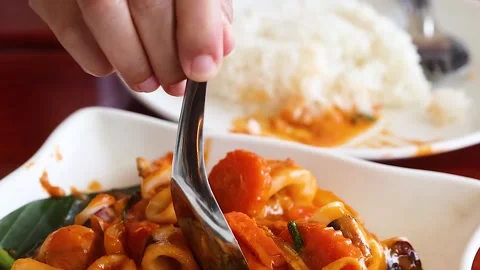 Close Up of Spoon Serving Stir Fried Squid with Salted Egg Stock Footage 329537187