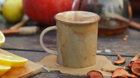 Close-up spoon stirring cocoa drink spilling on table. Full mug with beverage Video stock 237515625