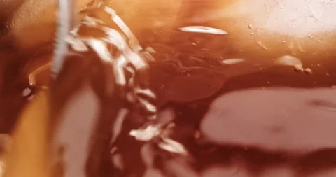 Close up spoon stirring iced coffee, tea, on ice cubes Slow Motion. Summer Drink Stock Footage 147571519