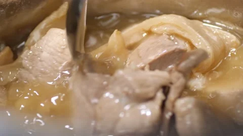 Close up of a spoon stirring stewed pork and melted lard. Video stock 204160004