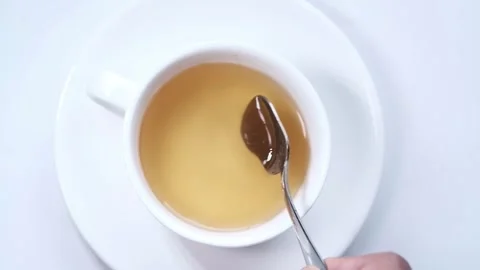 Close-Up of Spoon Stirring Vibrant Yellow Herbal Tea Video stock 343551667