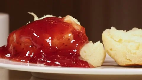 Close Up Of A Spponful Of Jam Being Added to A Freshly Baked Scone, UK Stock Footage 296038653