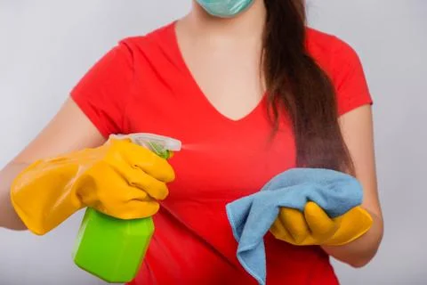 Close-up of spray bottle and rag in the hands of a cleaning lady. Stock Photos