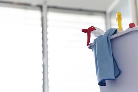 A close up of spray bottles in a bucket with a micro fiber cloth for Stock Photos