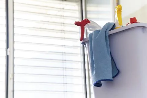 A close up of spray bottles in a bucket with a micro fiber cloth for Stock Photos