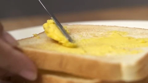 Close up spreading butter on a piece of bread. Stock Footage 79026834