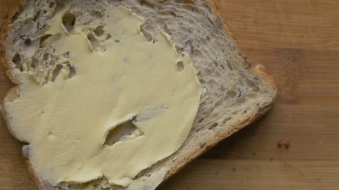 Close-up of spreading butter on a slice of wheat bread Stock Footage 75545739