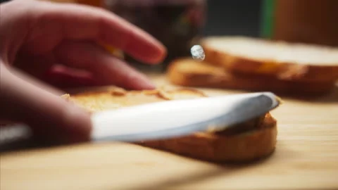 Close-up of spreading peanut butter on bread slice by the knife. Breakfast. Stock Footage 145292222