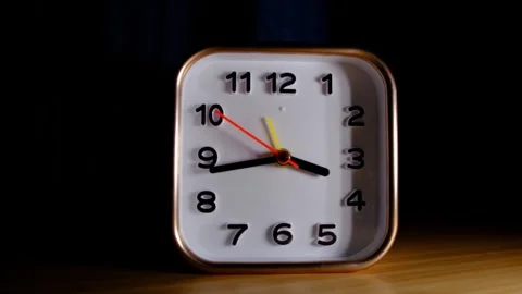 Close up of a square alarm clock on a desk, second hand ticking in sharp focus Video stock 329923105