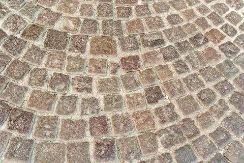 Close up of square granite setts in warm red and grey tones with rough surfaces Stock Photos
