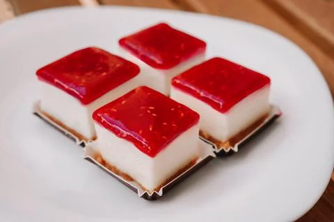 Close up of square raspberry cheesecakes on white plate 스톡 사진