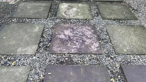 A close up of square stone pavers separated by small gravel with a weathered Foto stock