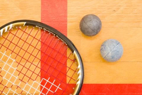 Close up of a squash racket and ball on the wooden background, sport concept 库存照片