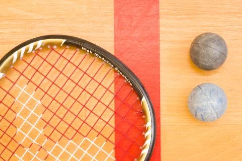 Close up of a squash racket and ball on the wooden background, sport concept 库存照片