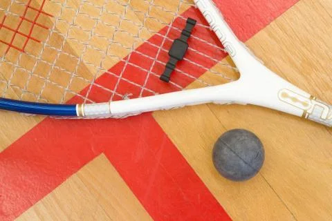 Close up of a squash racket and ball on the wooden background, sport concept 库存照片