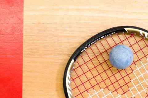 Close up of a squash racket and ball on the wooden background, sport concept 库存照片