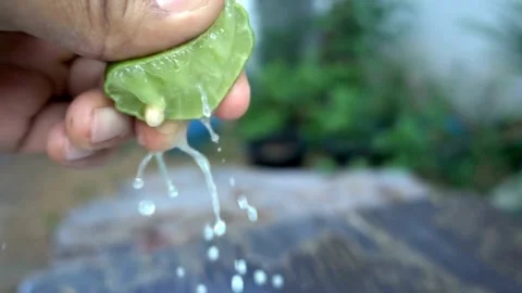 Close-up squeezing fresh lime juice by hand. squeezing juice of half a fresh Stock-Footage 336588809