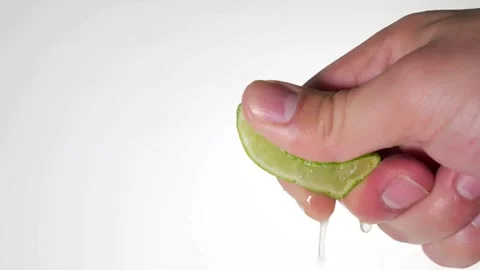 Close-up squeezing fresh lime juice by hand. squeezing juice of half a fresh Stock-Footage 336588822