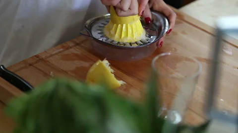 Close-up of squeezing lemon and pouring lemon juice into glass Stock Footage 59541533
