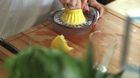 Close-up of squeezing lemon and pouring lemon juice into glass Stock Footage 59541535