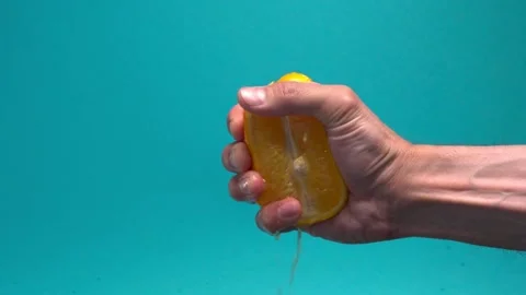 Close-up of squeezing orange juice with splashes by hand, making citrus fruit Stock-Footage 336588971