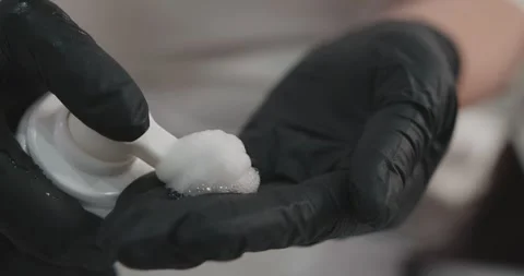 Close-up squeezing out a cream or ointment. A cosmetologist black latex gloves Stock Footage 316836115