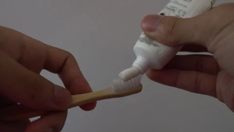 Close Up of Squeezing Toothpaste onto Bamboo Toothbrush Stock Footage 341834046