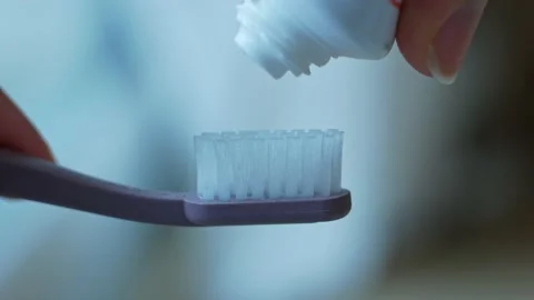 Close-up of squeezing toothpaste onto a recycled plastic toothbrush Stock Footage 187516528