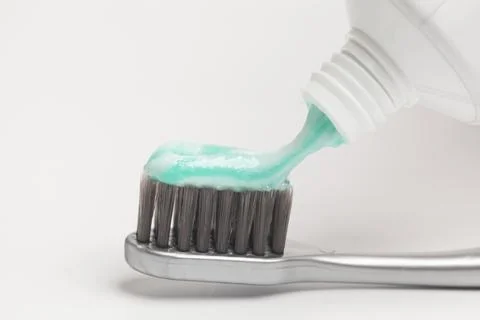 Close up of squeezing toothpaste on toothbrush on white background. 스톡 사진