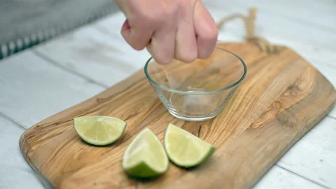 Close-up of squeezing wage lemon in a small glass bowl. Video stock 132788737