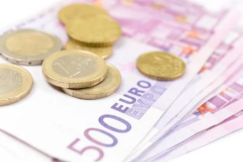 Close-up Stack of 500 Euro banknotes and coins, perspective view. Stock Photos