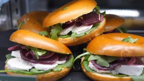 Close up of stack of bagels with cheese and beetroot displayed in deli shop Foto stock