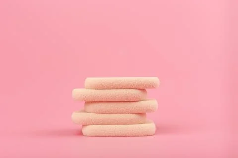 Close up of stack of beige make up sponges on pink background with copy space Stock Photos