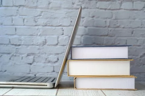 Close up of stack of books and laptop on table Stock Photos