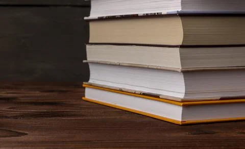 Close-up stack of books on a wooden table with space for text. Books in the Stock Photos