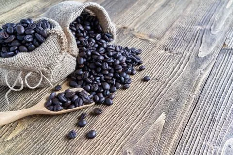 Close up stack of coffee bean on wooden spoon 库存照片