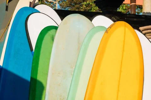Close up Stack of colorful surfboards on beach background for rent. Travel ad Stock Photos