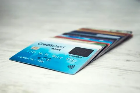 Close up of a stack of credit cards lying in order on the white table top. Many Stock Photos